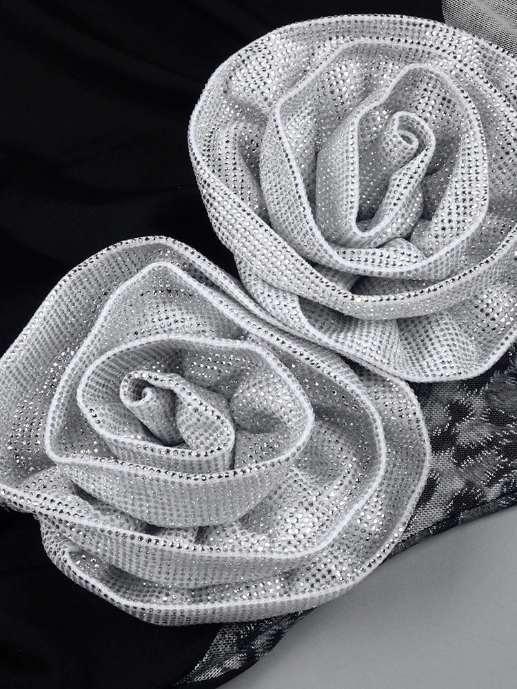 Two silver rose-shaped decorative elements on a black and gray background
