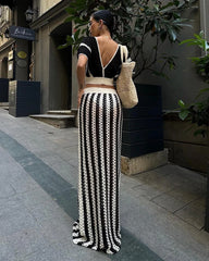 A model wearing a striped knitted dress set with a hollow-out long skirt and a V-neck crop top, posing on a street - Golden Atelier 3