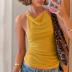 Person wearing a yellow tank top and blue jeans, taking a mirror selfie.