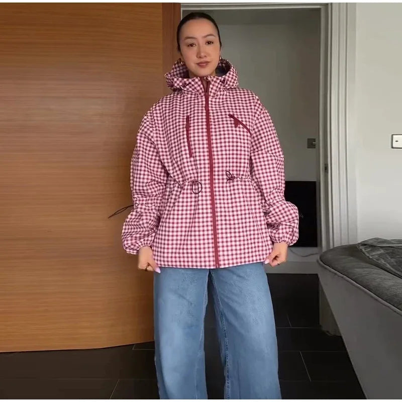 Person in pink gingham hooded jacket and blue jeans