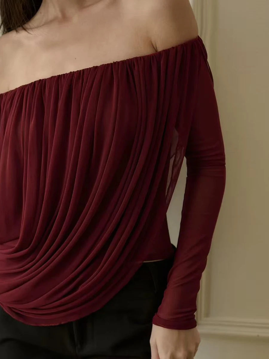 Maroon off-shoulder top worn by a person against a neutral background