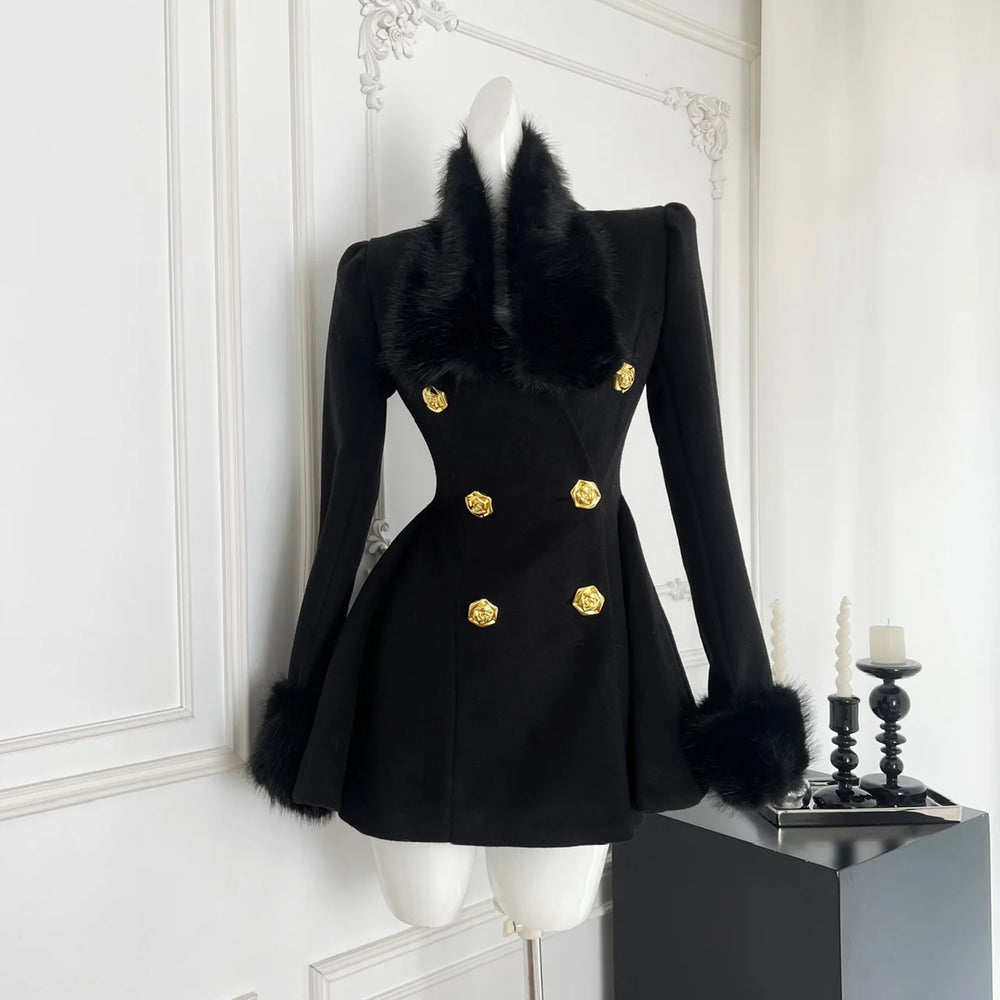 Black coat with fur collar and gold buttons on a mannequin against a white wall.