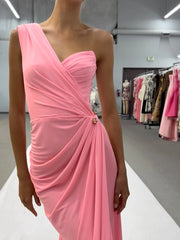 Person wearing a pink one-shoulder dress in a clothing store.