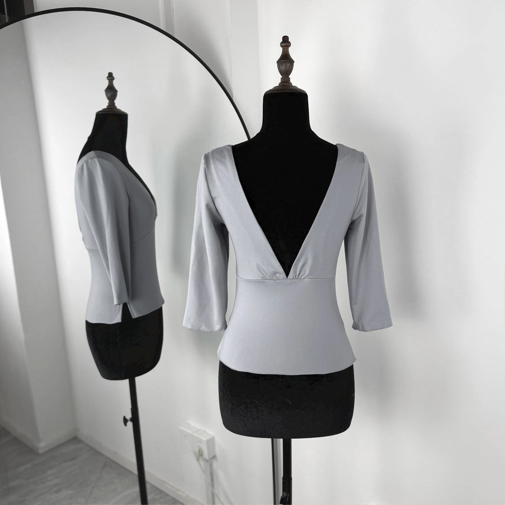 White blouse with a V-neck and three-quarter sleeves on a mannequin against a white background.