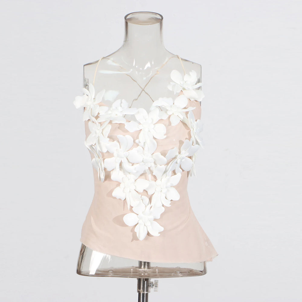 Mannequin wearing a light pink top with white floral embellishments on a white background