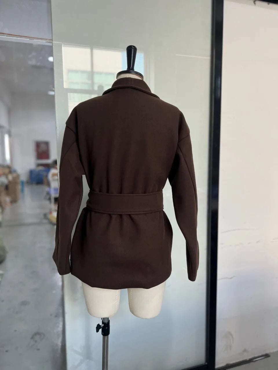 Brown jacket on a mannequin in a warehouse setting