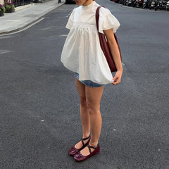 Person wearing a white dress and denim shorts on a street