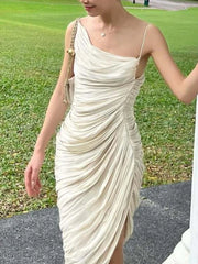 A woman wearing a beige one-shoulder dress with a green grass background