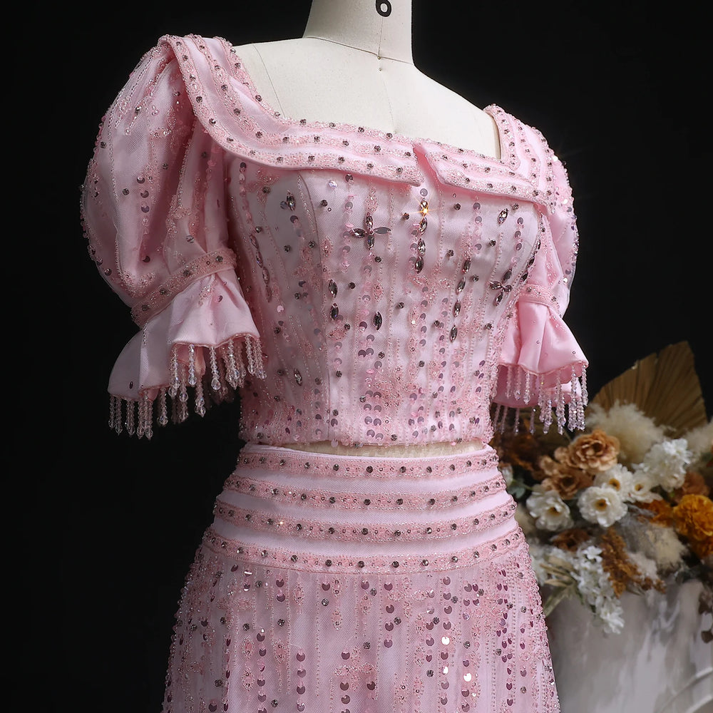 Pink embroidered dress on a mannequin with a dark background