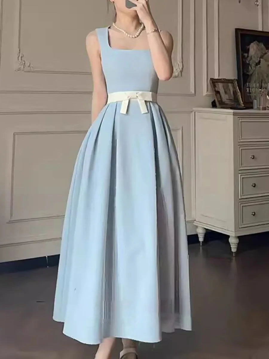Light blue dress with a white belt worn by a person in a room.