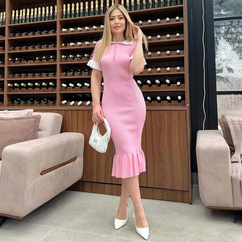Woman in a pink dress standing in a wine cellar