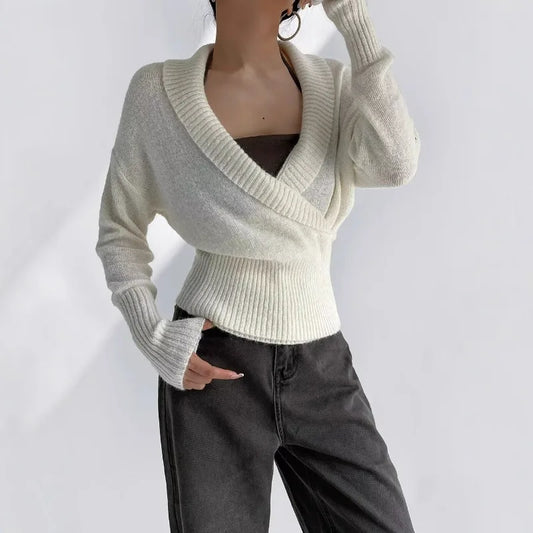 White knit wrap top with ribbed waist and long sleeves styled with jeans