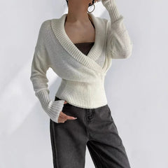 White knit wrap top with ribbed waist and long sleeves styled with jeans