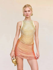 Woman wearing a gradient dress with yellow and orange tones on a beige background