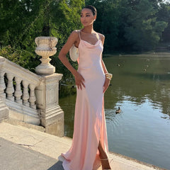 Woman in a pink dress standing by a lake with ducks