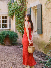 A vintage-inspired red polka dot dress with a square neck, backless design, and a slim fit.