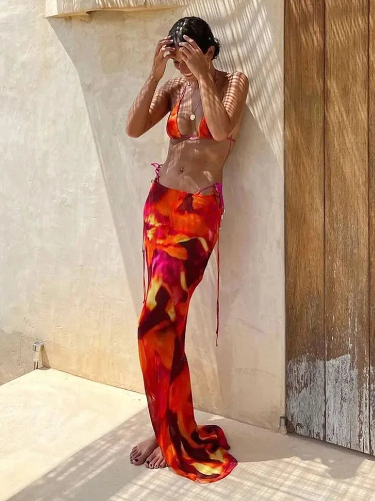 Abstract print mesh maxi skirt and bikini top leaning against wall