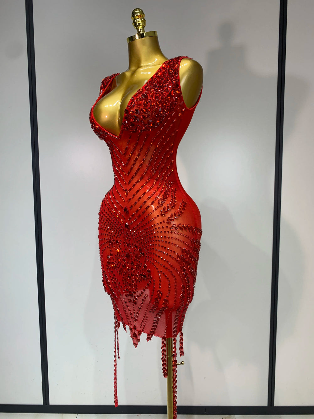 Red beaded dress on a mannequin against a neutral background