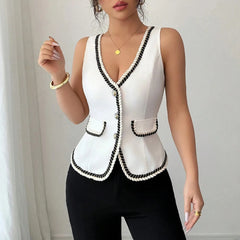 Woman wearing a white vest with black trim against a neutral background