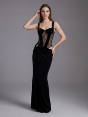 Woman wearing a black evening gown with sheer lace details on a gray background