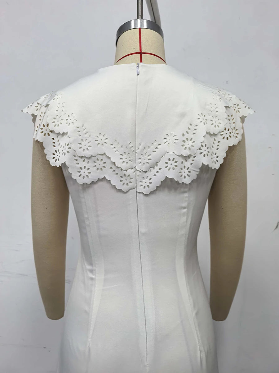 White lace-trimmed top on a mannequin against a plain background