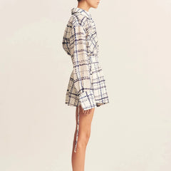 Plaid dress worn by a person on a beige background