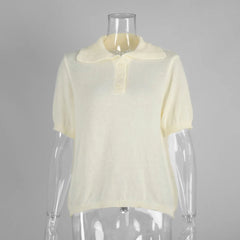 Mannequin wearing a light yellow short-sleeve sweater against a gray background