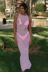 Woman wearing a pink and gray dress with starfish designs in an outdoor setting.