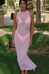 Woman wearing a pink and gray dress with starfish designs in an outdoor setting.