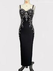 Black evening gown with silver beading on a mannequin against a white background