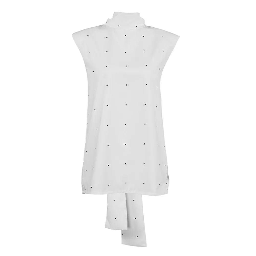 White sleeveless top with black polka dots on a white background