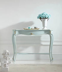 Decorative console table with a vase of flowers and a statue on a white background