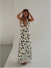 White polka dot maxi dress with a plunging neckline and open back.