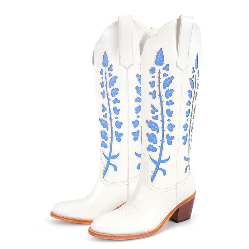 White cowboy boots with blue floral patterns on a white background