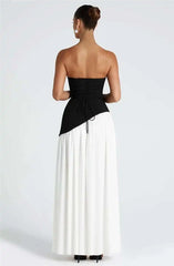 Woman wearing a black and white strapless dress on a plain background