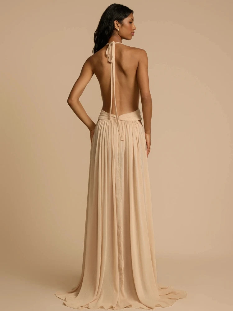 Woman wearing a beige evening gown with a backless design on a beige background