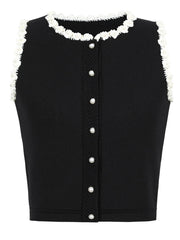 Black sleeveless top with white lace trim and buttons on a white background