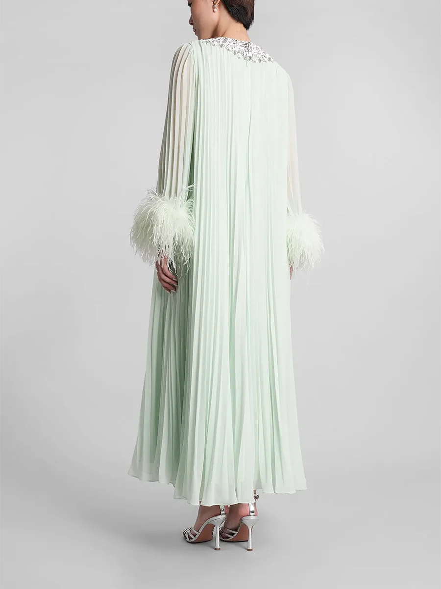 Light green dress with feathered sleeves on a gray background