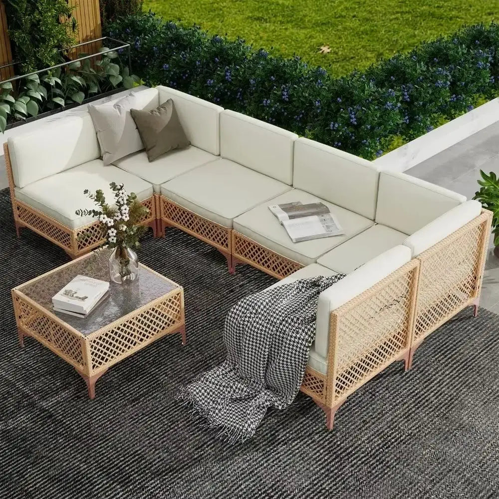 Outdoor patio furniture set with beige cushions and wicker design on a patio.