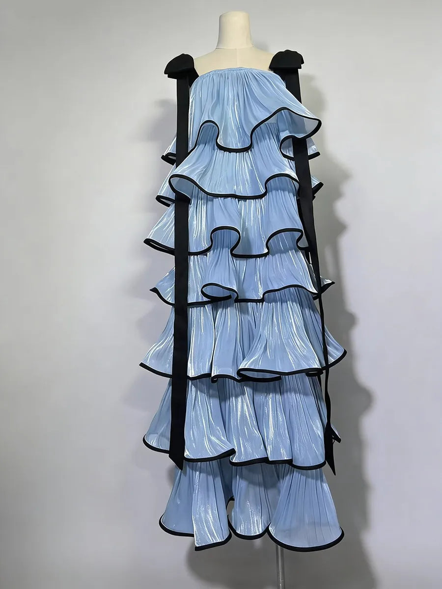 Mannequin wearing a light blue dress with black ruffled straps on a white background