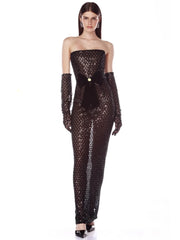 Woman wearing a black sequin jumpsuit with long gloves on a white background