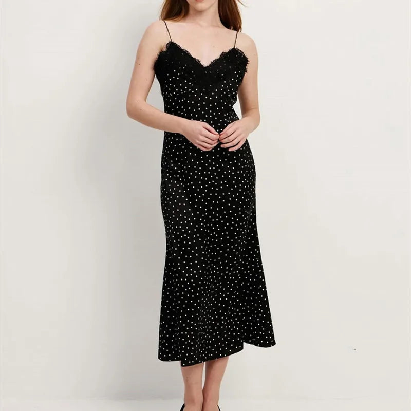 Black polka dot dress worn by a person on a white background