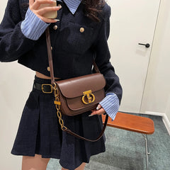 Brown PU leather shoulder bag with gold chain styled on neutral outfit