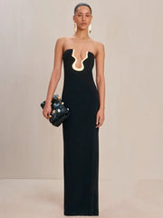 Strapless black maxi dress with gold neckline detail and a fitted silhouette.