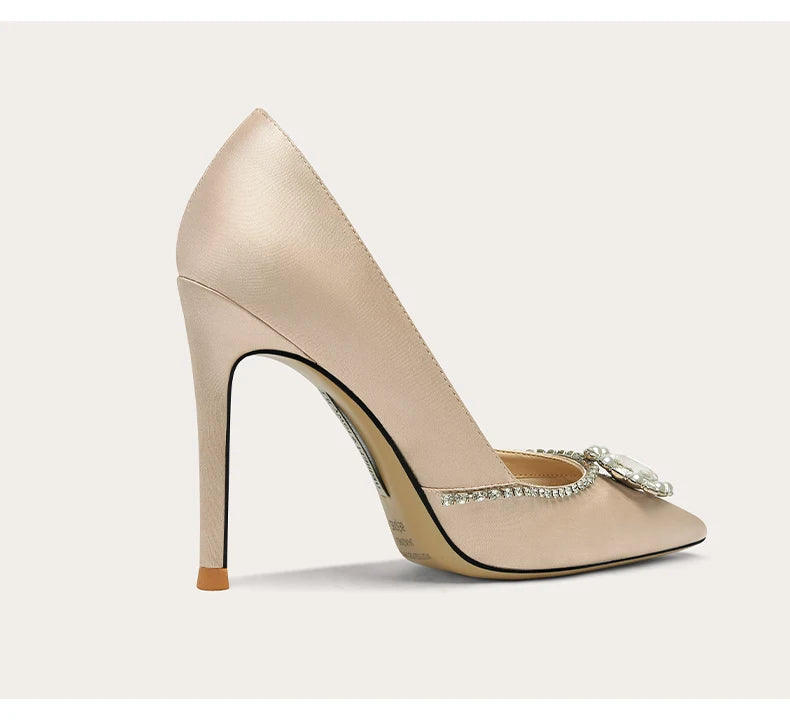 Beige high-heeled shoe with a decorative bow on a light gray background