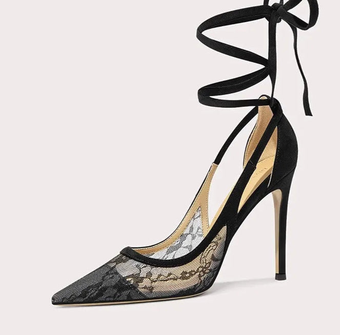 Black lace high-heeled shoe with tied straps on a white background