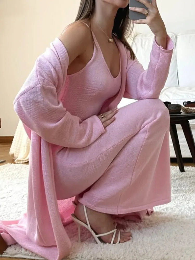 Woman in a pink outfit sitting on the floor in a room.