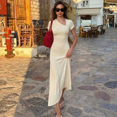 Diagonal neck asymmetrical hem midi dress in apricot on cobblestone street