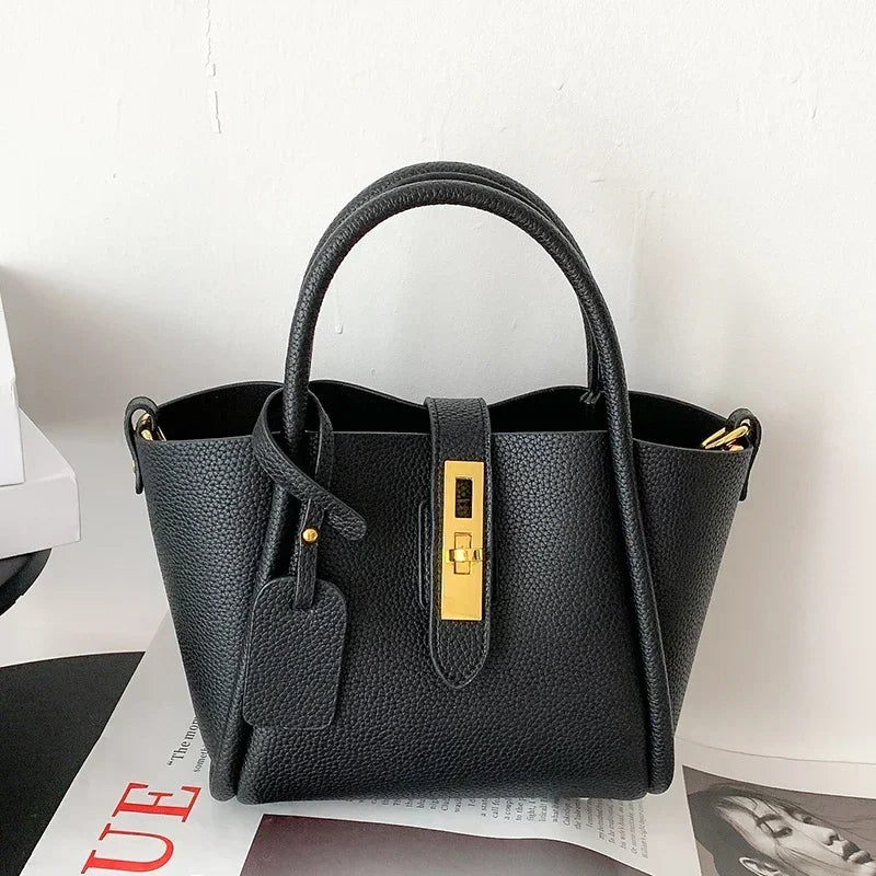 Black handbag with gold accents on a white background