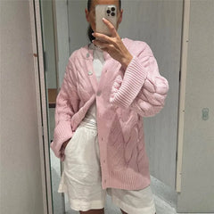 Person wearing a pink knitted cardigan taking a mirror selfie.